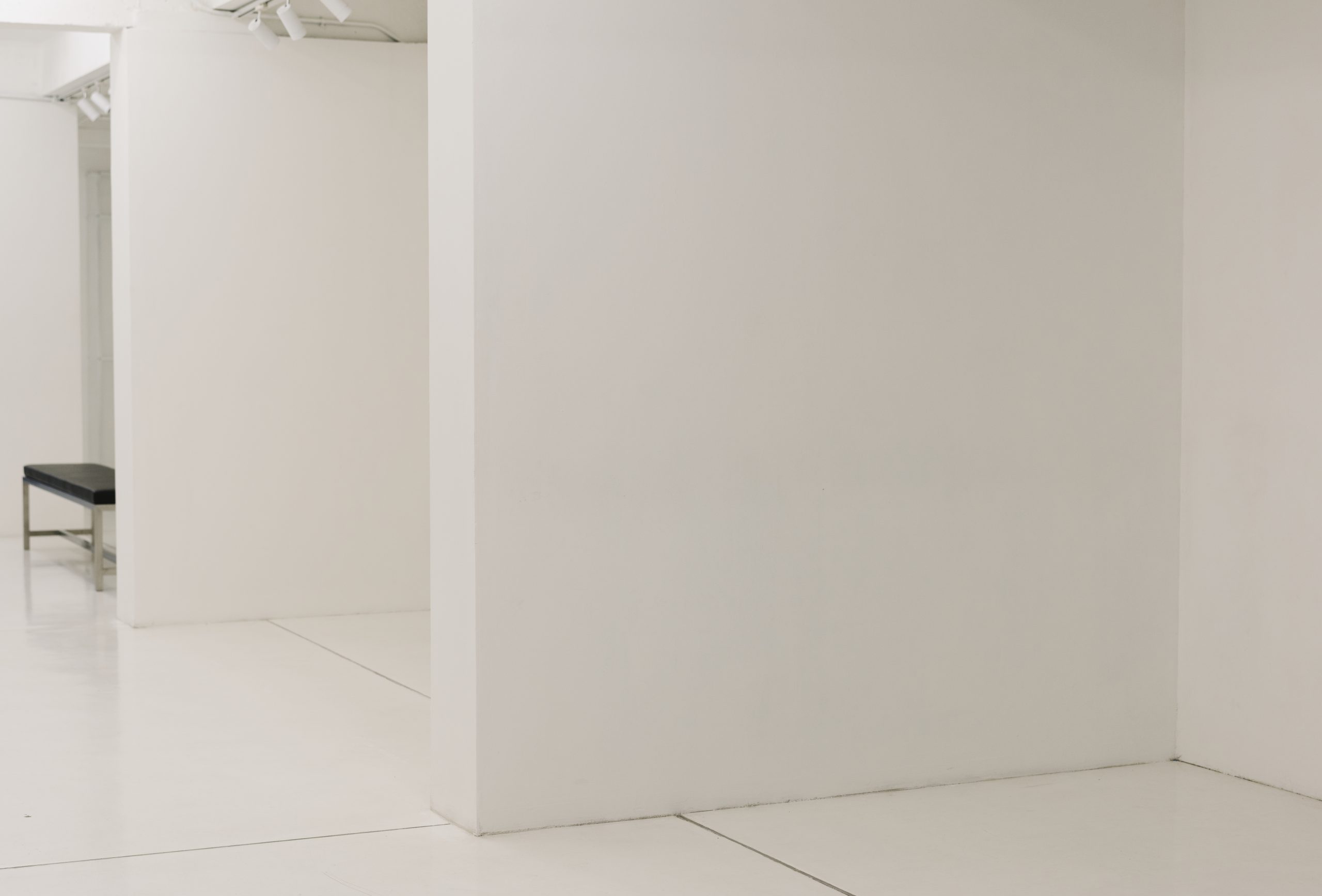 White exhibition room with a bench